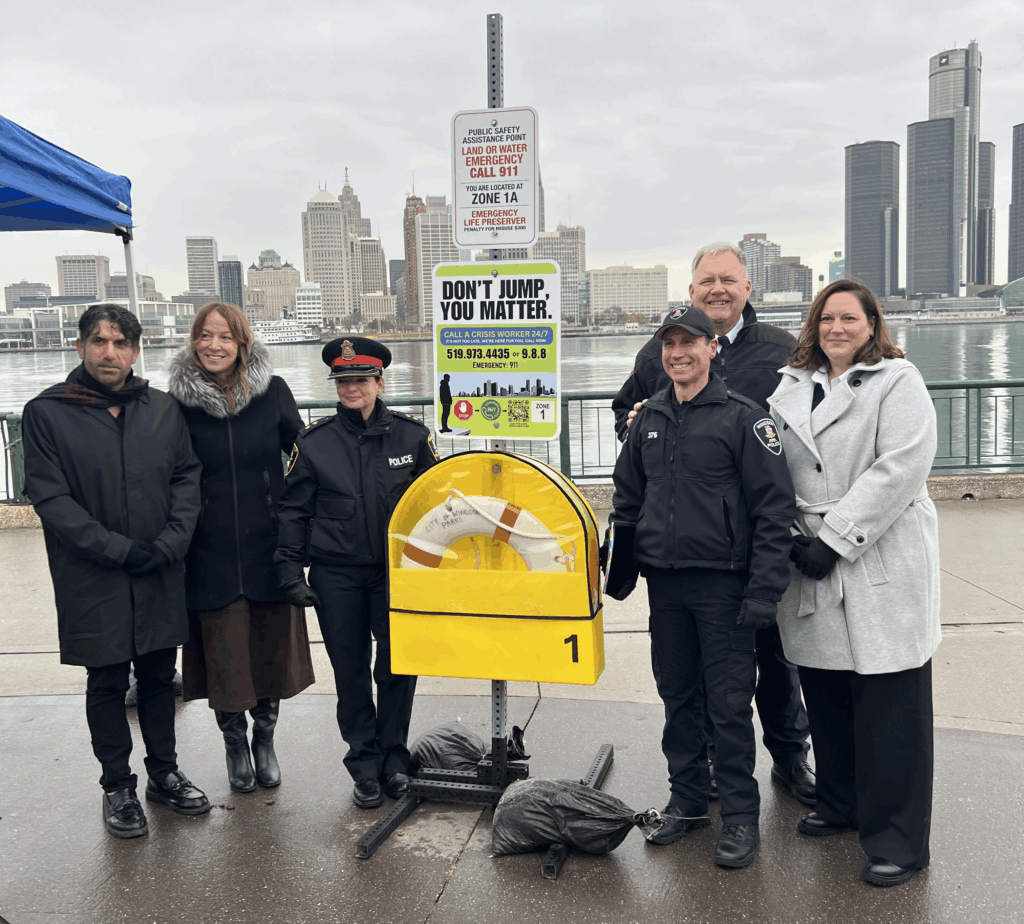 Cette image montre l'Autorité du Pont Windsor-Détroit et ses partenaires dévoilant un panneau vert portant un message de prévention du suicide.